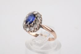A rose gold sapphire cluster ring. Set with one oval faceted sapphire of circa 0.