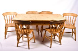 A vintage pine kitchen table and set of six contemporary pine farmhouse Windsor dining chairs.