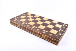A carved wooden chess set in a folding board box. Board 55cm x 55cm, height of king 11cm.