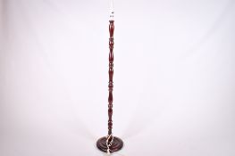 A contemporary wooden standard lamp. The turned column mounted on a circular base.