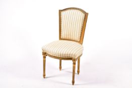 A French Louis XVI style giltwood dining chair with cream stripped upholstery.