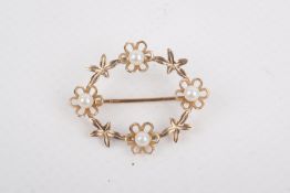 A 9ct gold and cultured pearl wreath brooch. Decorated with flowers, hallmarked 2.7cm x 3.