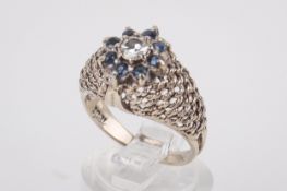 A diamond and sapphire dress ring. One brilliant round cut diamond of circa 0.