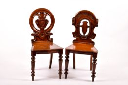 Two 19th century mahogany hall chairs.