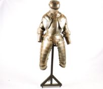 A reproduction part suit of armour. The metal structure mounted on a wooden stand, H185cm.