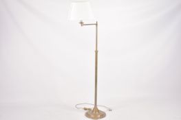 A solid brass telescopic swing arm standard lamp raised on a circular base.