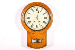 An oak cased drop dial wall clock. Dial 32cm diameter. Key & pendulum present.