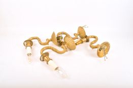 Four contemporary brass wall light sconces. Having asymmetric cast brass decoration.