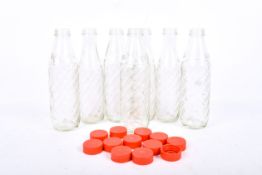 A set of seven vintage glass 'Soda Stream' bottles with red screw on tops.