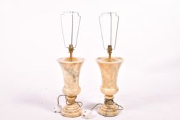A pair of Italian marble table lamps raised on circular bases.