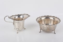 A George V silver sugar bowl and cream jug.