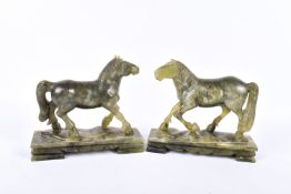 A pair of Chinese green soapstone carvings of horses. Each astride a footed base, H14.5cm x L16.5cm.
