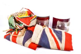 A collection of vintage flags, bunting and two pairs of lamp lenses.
