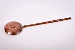 A Victorian copper bed warmer. Attached to a turned wooden handle, L118cm.