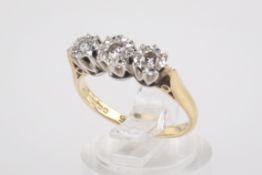 An 18ct gold and three stone diamond ring. The three round brilliant cut diamonds of circa 0.