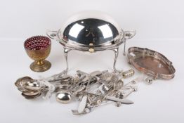 A group of silverplated items including cutlery and a large serving dish.