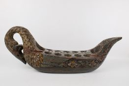 A carved wood congkak (mancala) game board.