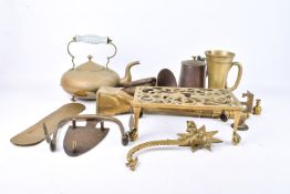 A collection of miscellaneous brass items. Including a trivet, a kettle and a hose nozzle, etc.