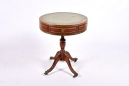 A 20th century Regancy style drum top table with green inset leather top.