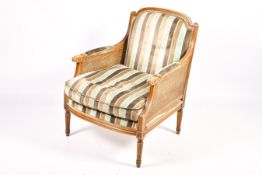 A French Bergere mahogany style armchair with stripped blue and brown upholstery.