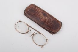 A pair of rose metal framed spectacles. Marked '9ct', L9.5cm, 11.6g gross, in a leather case.