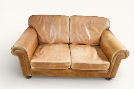 A contemporary two seater brown leather sofa with scroll arms.