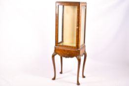 A 1920s walnut veneered display cabinet.