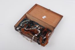 A wooden box full of assorted beads.