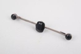 A silver and dark blue stone bar brooch.