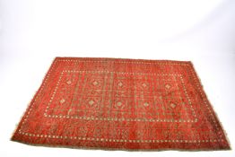 Rectangular oriental rug on a red ground. Having geometric borders.
