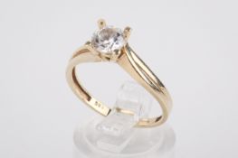 A yellow metal dress ring set with a round cubic zirconia.