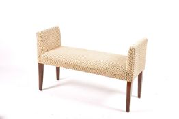 A contemporary upholstered window seat. Raised on square tapering supports.