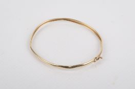 A bicolour gold bangle.