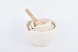 Two 19th century stone and a 20th century ceramic mortar and one pestle.