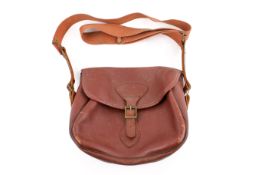 A vintage Gunmark brown leather shotgun cartridge bag with shoulder strap.