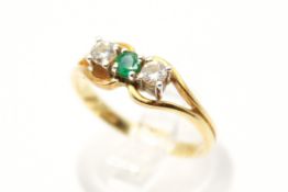 An 18ct gold, diamond and emerald dress ring. With two diamonds of 0.