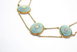 A yellow metal and turquoise Etruscan style necklace.