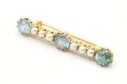 An early 20th century bar brooch. Set with three round faceted zircons, each of 6.