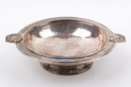 An Omar Ramsden Stirling silver hallmarked footed bowl. With Tudor rose handles and hammered finish.