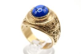 An American Collegiate ring set with a blue oval cabochon cut imitation gemstone.