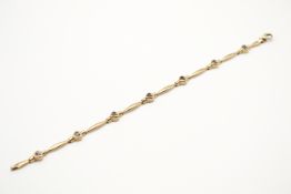A hallmarked 9ct gold panel bracelet set with heart shaped faceted imitation gemstones. 7.