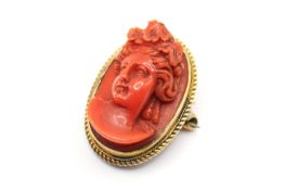 A late 19th/early 20th century yellow metal mounted coral cameo brooch.