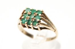 A hallmarked 9ct gold dress ring. Set with round faceted emeralds of 0.