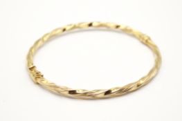 An Italian 9ct gold hinged bangle. Of twisted form, marked 9k, width of twist circa 3.