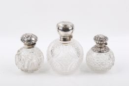 Three silver topped scent bottles.