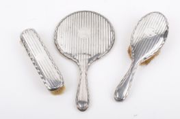 An early 20th century silver mounted three-piece brush and mirror set.