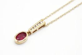 A 9ct gold and ruby pendant and chain. The pendant set with an oval faceted ruby of circa 0.