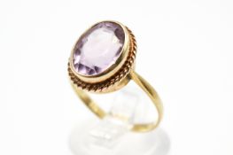 A yellow metal and amethyst ring.