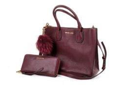 A burgundy Michael Kors handbag, pompom and matching purse.