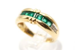 An emerald and diamond set dress ring. The emeralds of 0.50 carats estimated total weight.